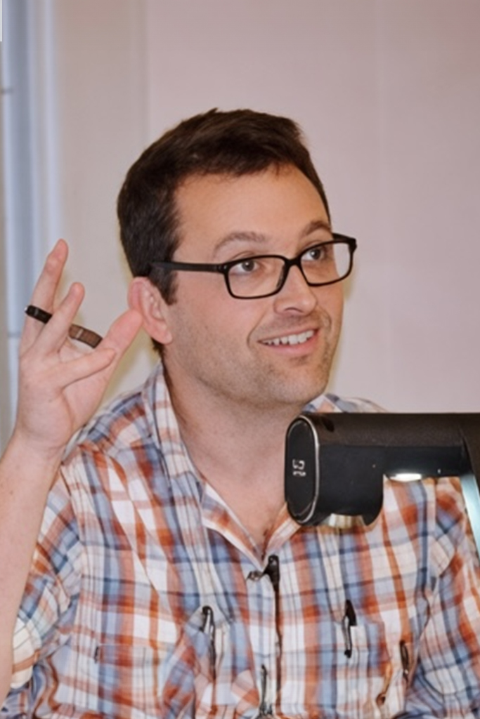 a man in glasses looking at the camera